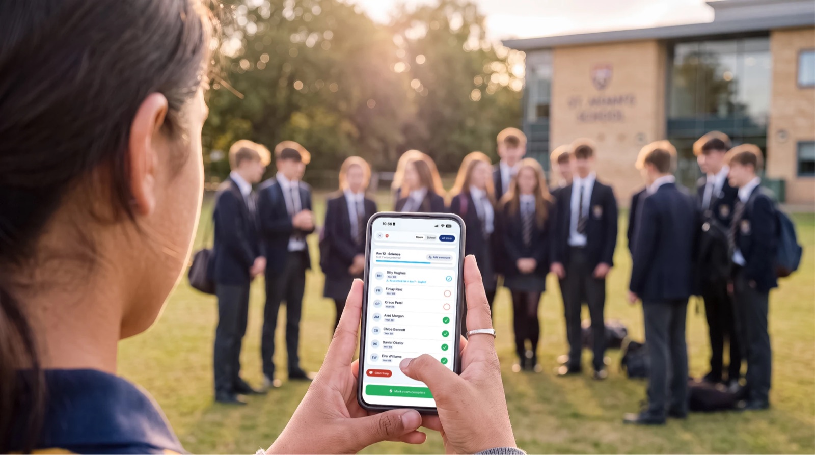A teacher taking the roll call on her phone at the assembly point
